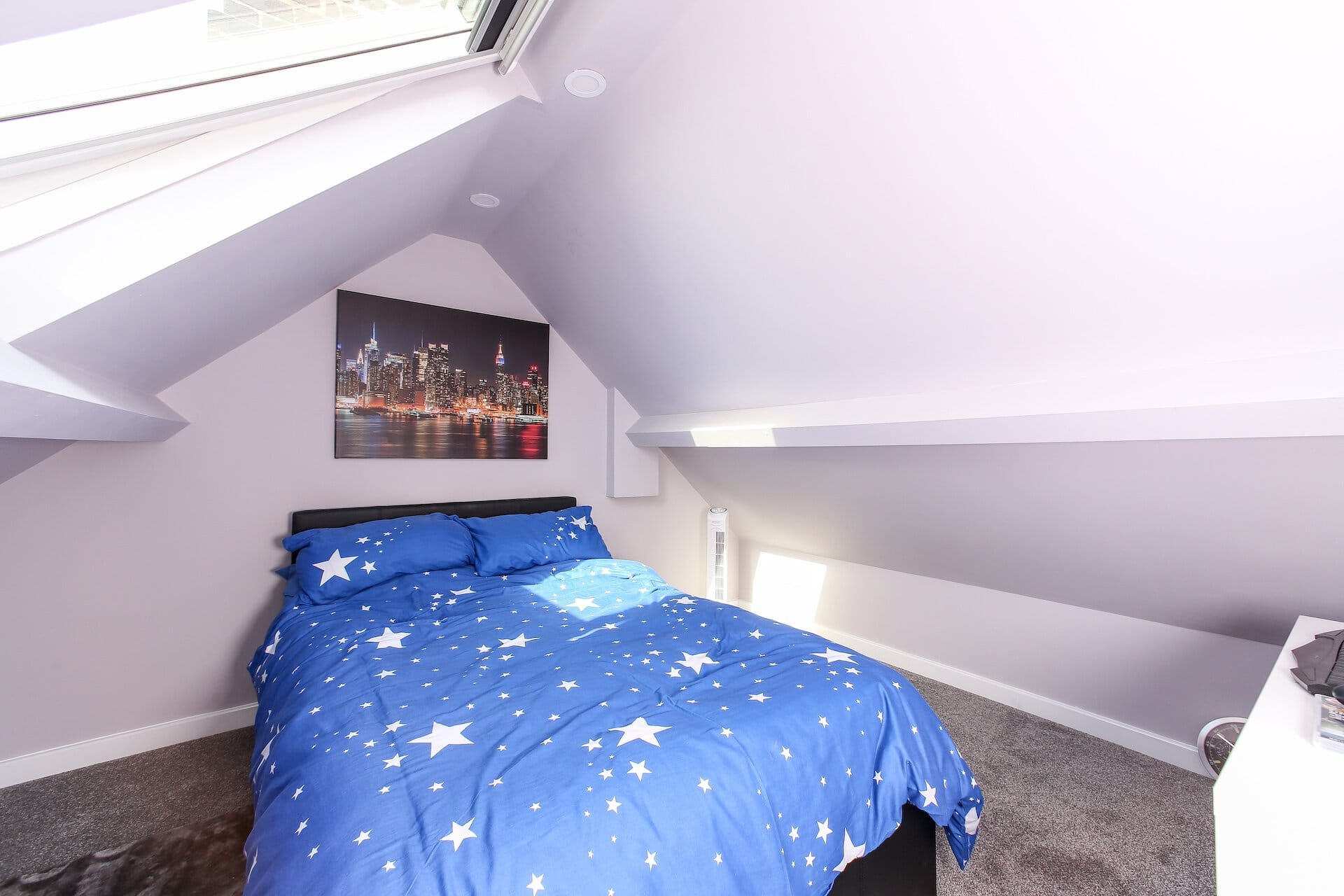 Finished loft bedroom with roof windows and sloped ceilings